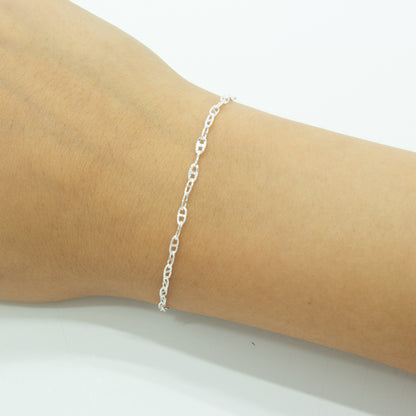 A delicate silver chain bracelet with interlocking oval links, shown worn on a person's wrist against a plain white background.